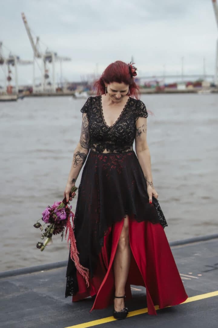 Schwarz-rotes Brautkleid für eine Motto-Hochzeit, mit verspielten Details und einem eleganten, dramatischen Look.