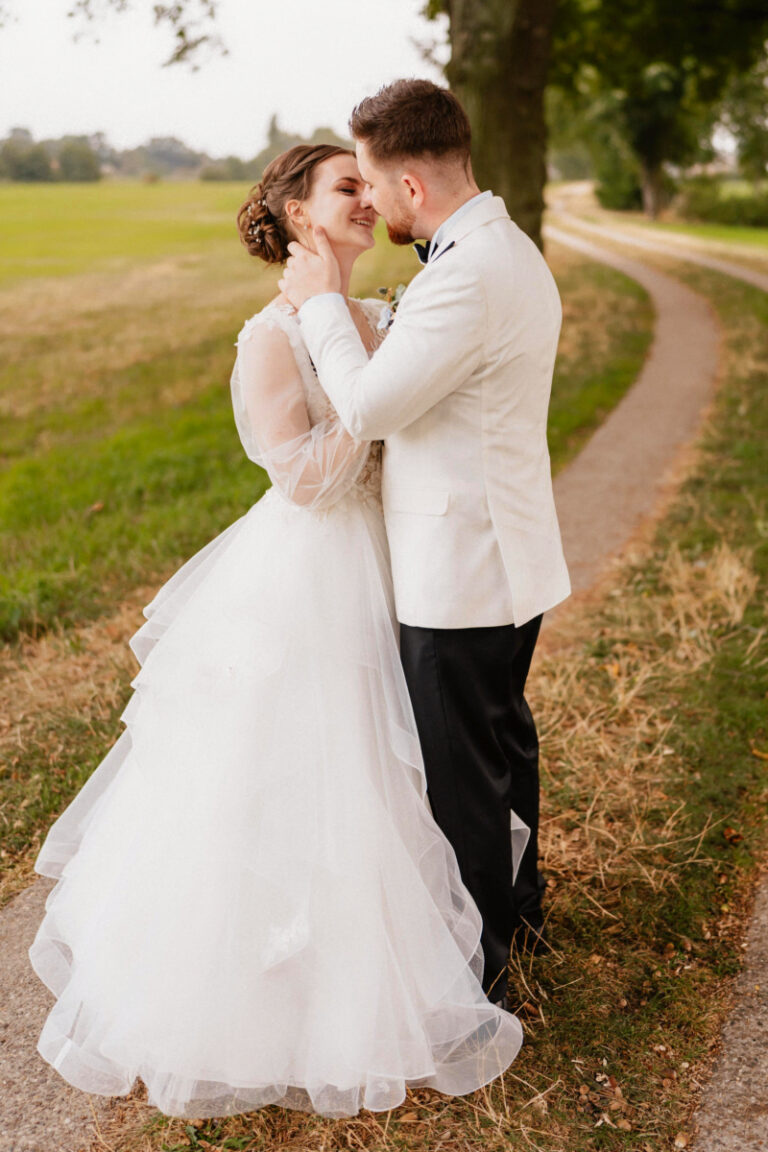 Braut-mit-Volant-Kleid-und-Mann-kuessen-sich