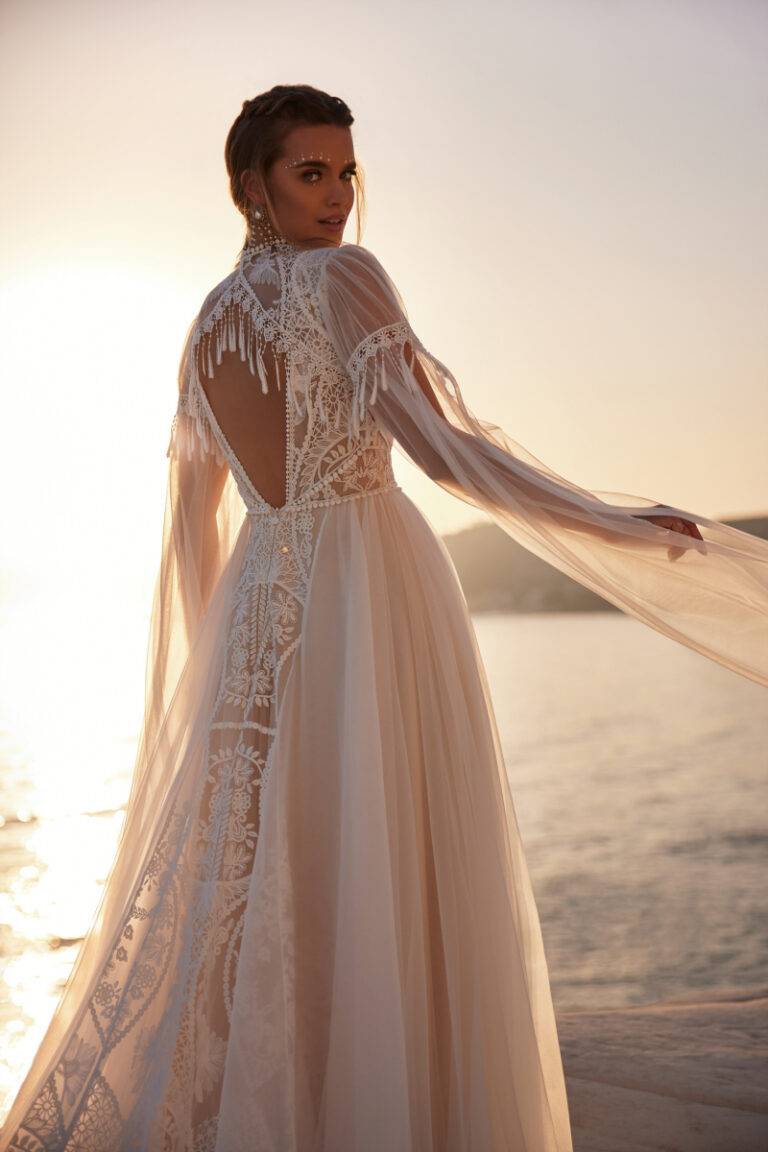 ANWAR Brautkleid von Dama Couture im Boho-Stil mit gehaekelter Spitze und Cape-Ärmeln – Brautmode, Braut am Strand bei Sonnenuntergang
