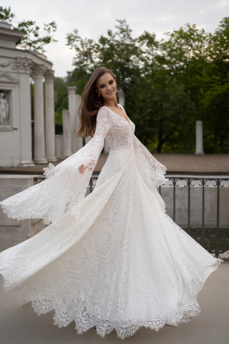 Boho-Brautkleid Lea von Dama Couture mit V-Ausschnitten und Häkelspitze – Brautmode, Portraitaufnahme im Park
