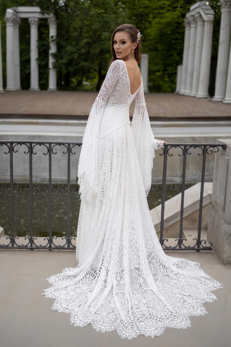 Boho-Brautkleid Lea von Dama Couture mit Häkelspitze und langer Schleppe – Brautmode, Ganzkörperansicht im Schlosspark
