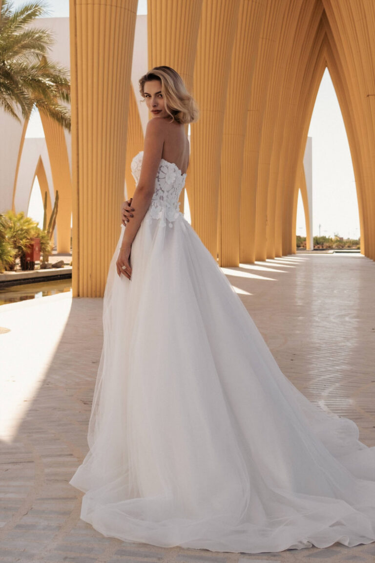 DAVINA Brautkleid trägerlos mit Spitzenoberteil und Tuellrock – VeryNice Brautmode Lüneburg Winsen, Rückenansicht unter Bogengang