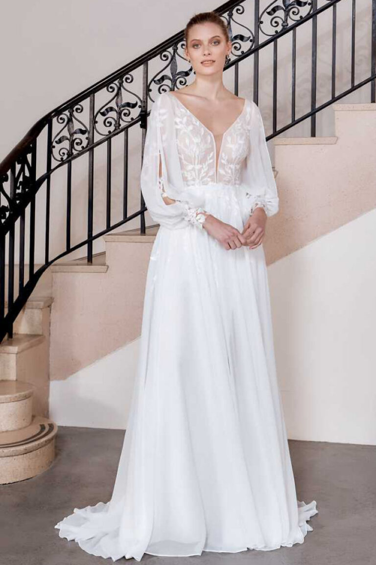 Hunter Brautkleid mit tiefem V-Ausschnitt und Blumenstickerei – VeryNice Brautmode Winsen bei Hamburg, Vorderansicht an Treppe