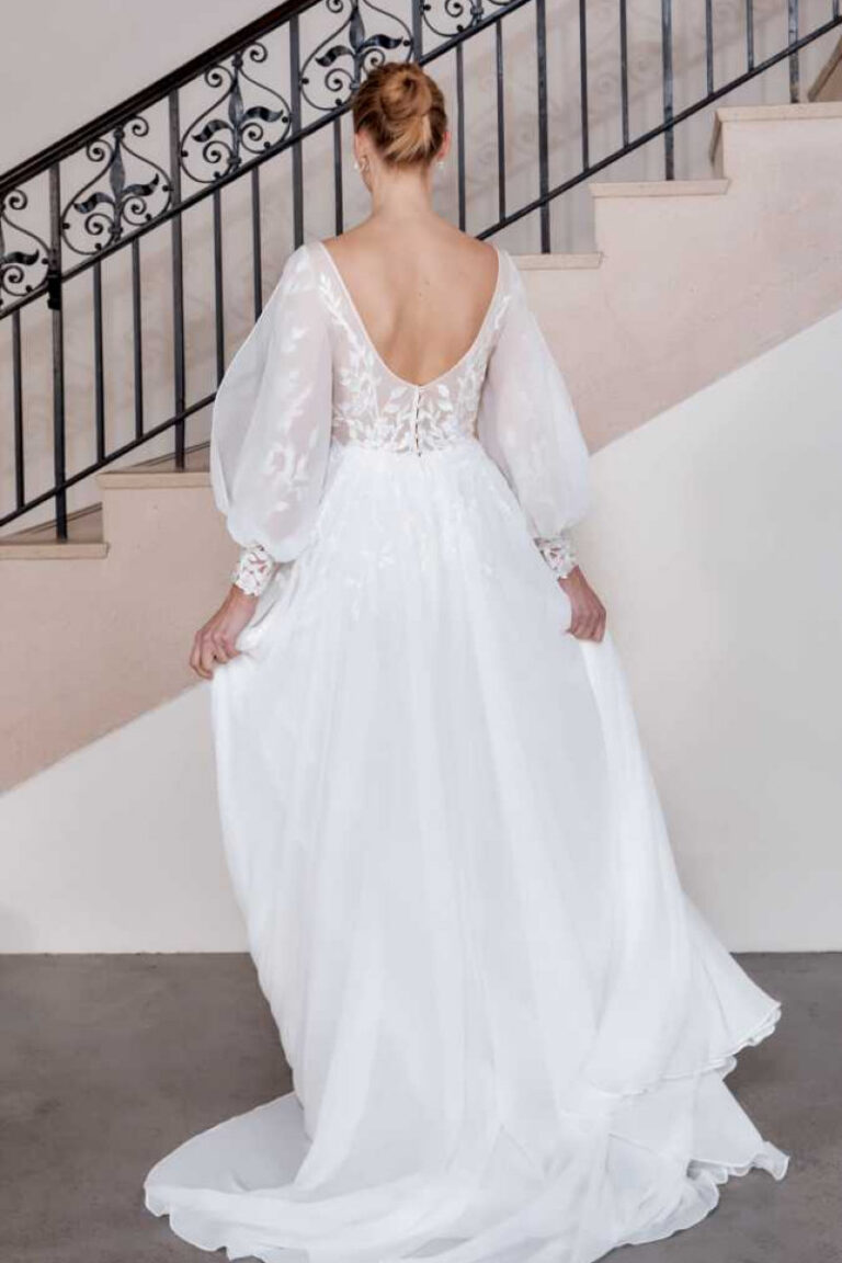 Hunter Brautkleid mit langen Puffärmeln und tiefem Rückenausschnitt – VeryNice Brautmode Winsen bei Hamburg, Rückenansicht an Treppe