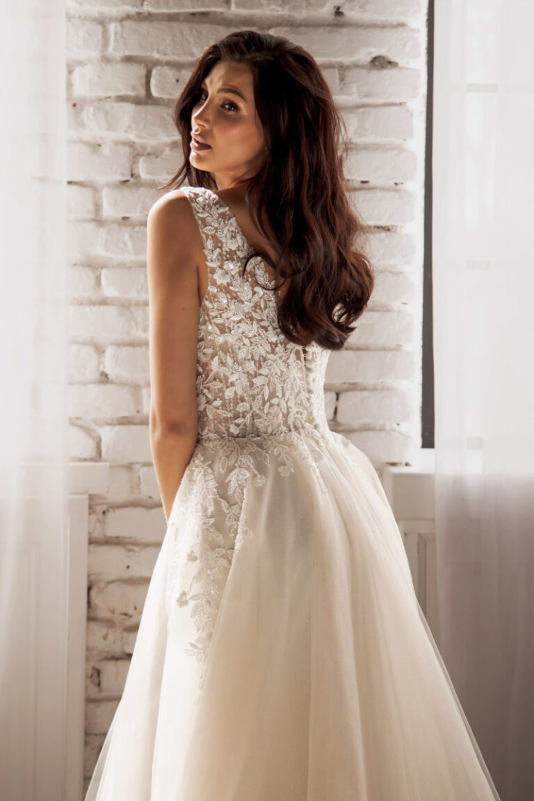 MAKENA Boho-Brautkleid mit Spitzenoberteil und ärmellosem Schnitt – Brautmode Lüneburg Hamburg, Braut vor Backsteinwand
