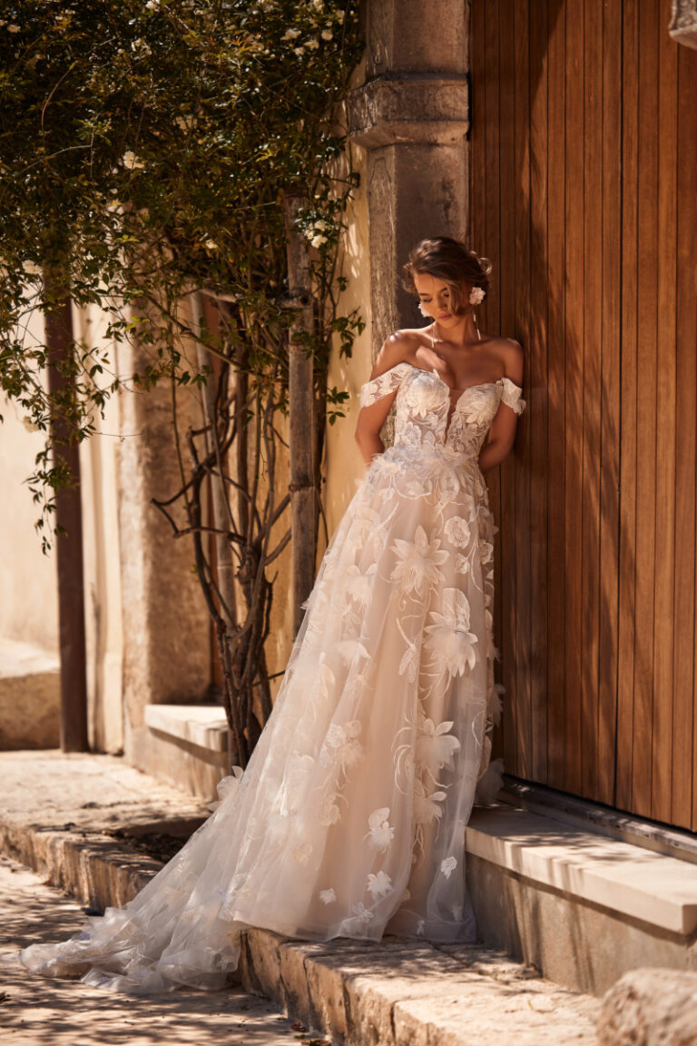 Nenufar Boho-Brautkleid mit 3D-Blumenspitze und Tuellschleppe – Brautmode Hamburg, Ganzkörperansicht an Steintreppe